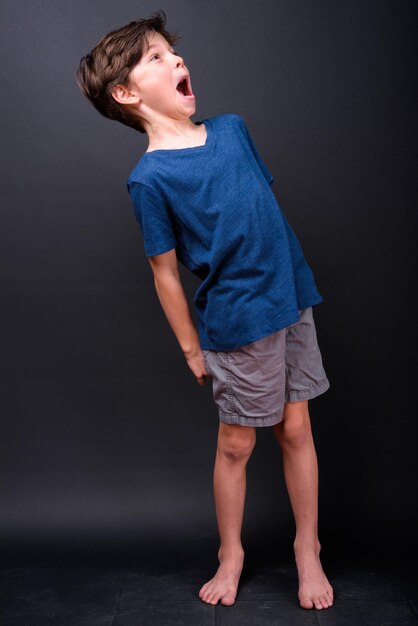 Boy standing against black background