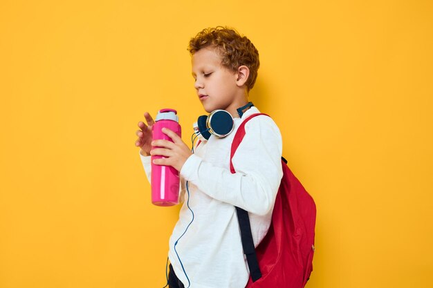 Boy standing against yellow background