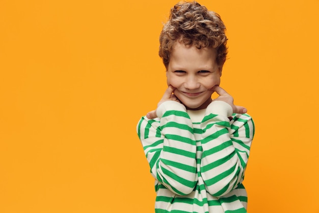 Boy standing against yellow background