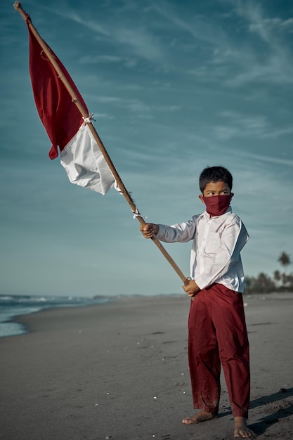 Photo boy standing on beach against sky