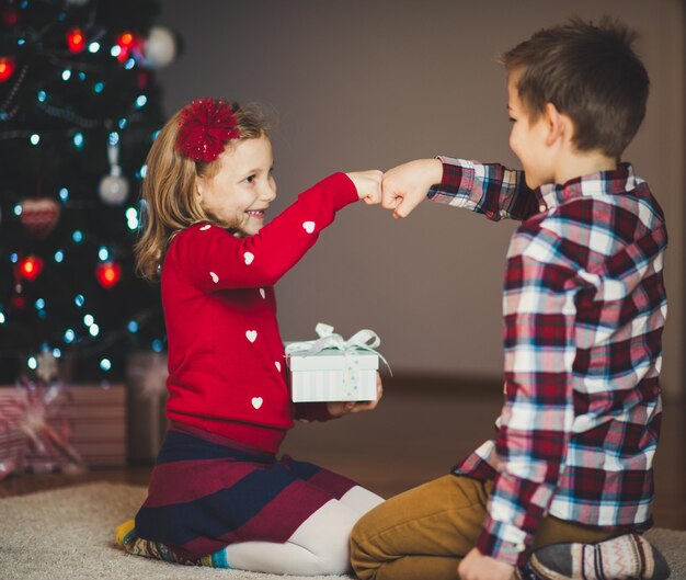 Foto ragazzo in piedi vicino all'albero di natale