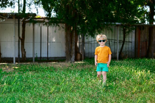 Boy standing on grass against trees