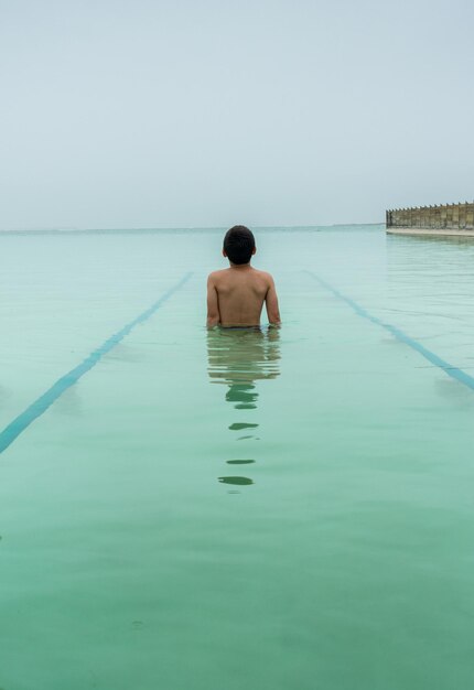 写真 水の中に立っている少年