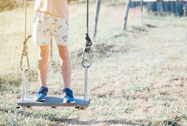 Boy standing on swing