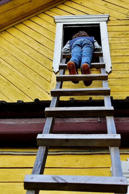 Photo boy standing on wooden ladder