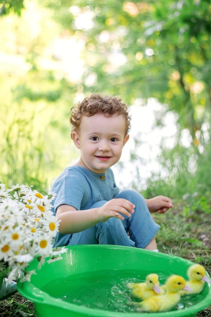 Photo a boy on the street is playing with ducklings photo session happiness childhoodxaxa