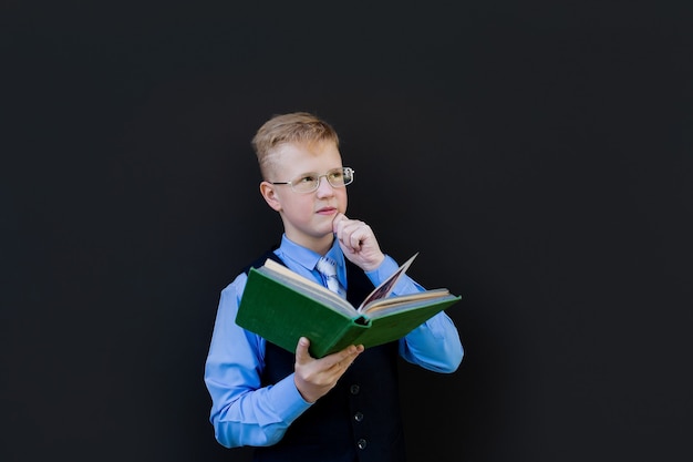 The Boy student with a book on a black background