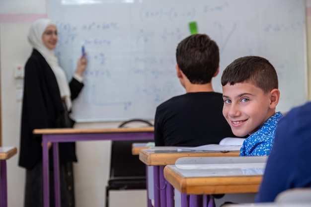 Boy studying in school with his colleagues