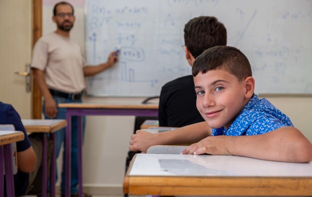 Boy studying in school with his colleagues