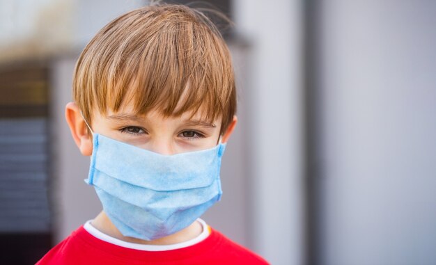 Boy in surgical mask in the street