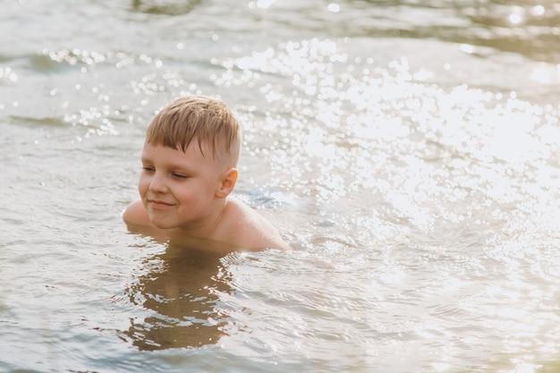 写真 湖で泳ぐ少年。