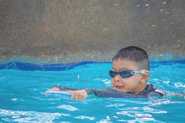 写真 プールで泳いでいる少年