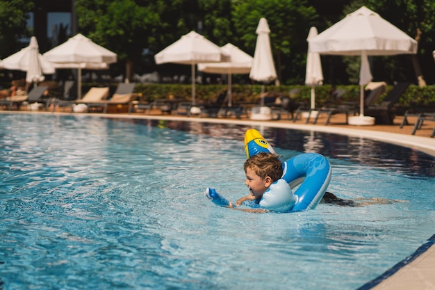 Photo a boy in a swimming pool on a sunny day