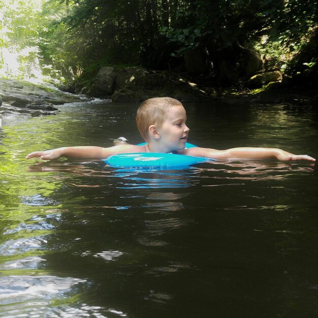 Photo boy swimming in stream