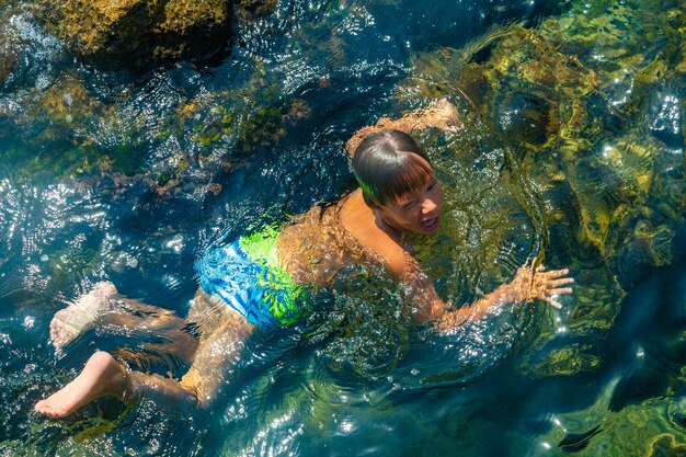 Boy swimming underwater beautiful view of crystal clear transparent water of sea