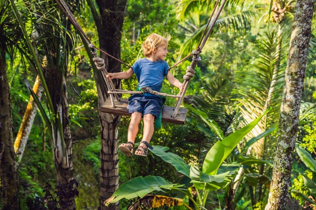 A boy on a swing over the jungle, Bali.