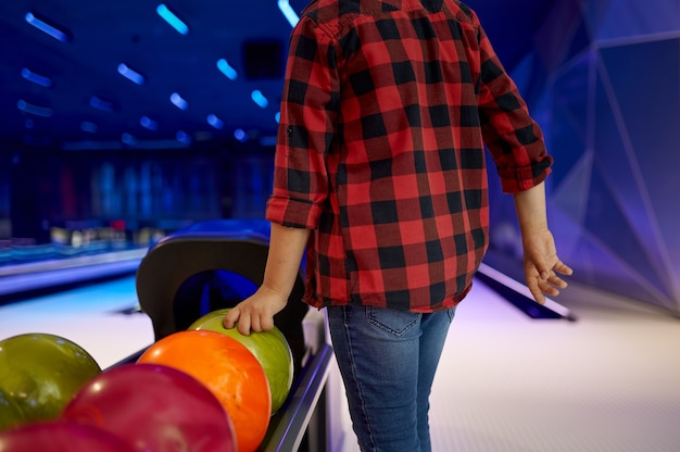 Foto il ragazzo prende una palla sulla corsia di bowling