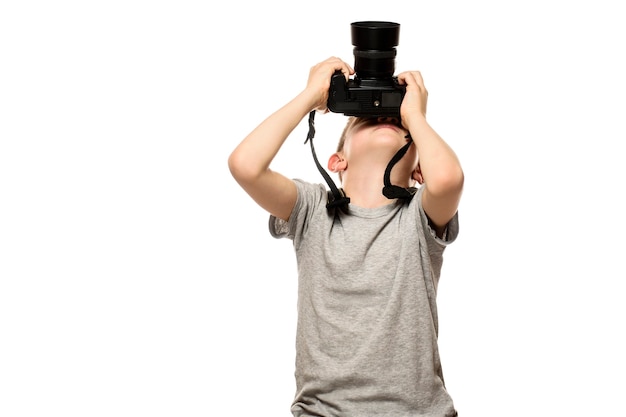 Boy takes pictures on the camera. portrait. isolate on white background.