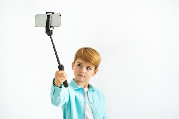 The boy taking a selfie on the white background