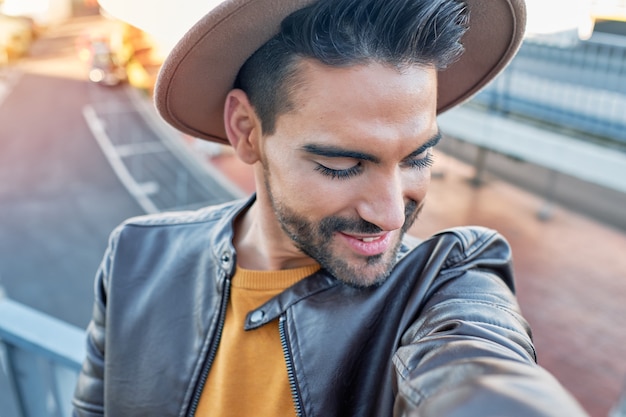 Boy taking a selfie with a hat and leather jacket