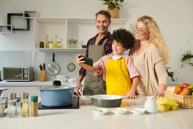 Photo boy taking selfie with parents