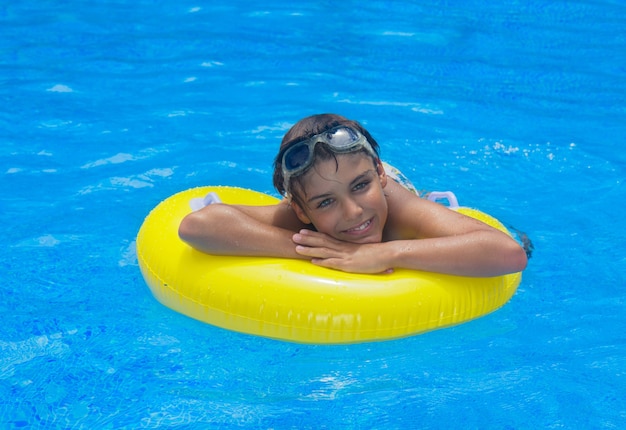 Boy taking sunbath in pool on rubber ring