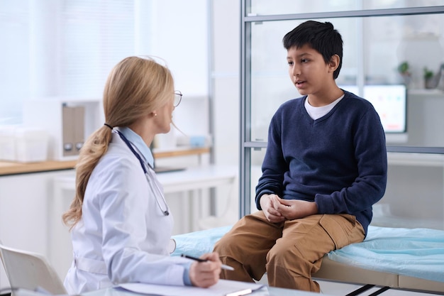 Photo boy talking to doctor in clinic