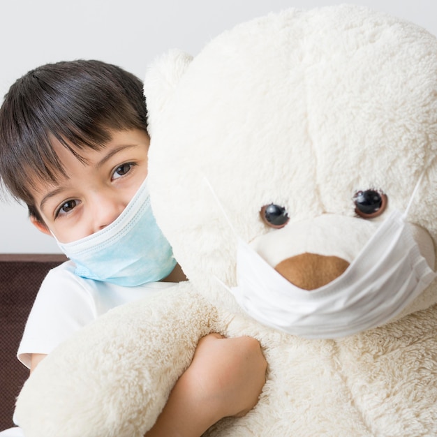 Photo boy and teddy bear with mask