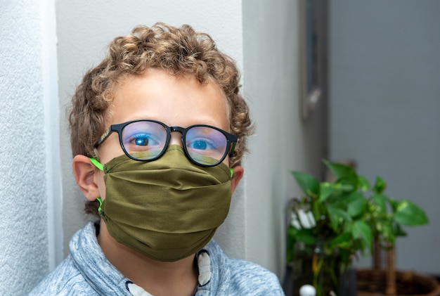 Boy teenager teen male child wearing face mask  in the Coronavirus COVID-19 pandemic