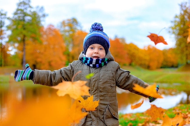 The boy throws autumn leaves Autumn article A happy child Autumn