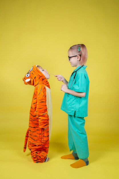 Boy in tiger costume shows throat to pediatrician at doctors appointment