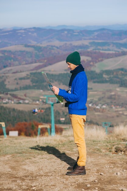 boy tourist in mountains with map