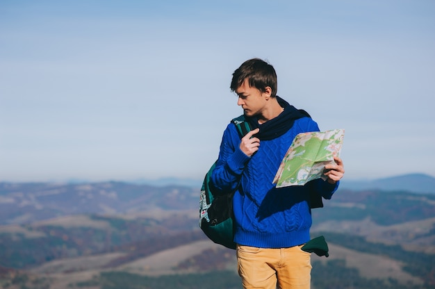 boy tourist in mountains with map