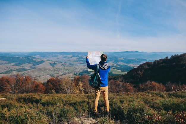 boy tourist in mountains with map