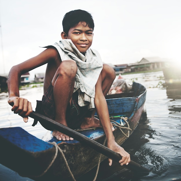 Мальчик путешествует на лодке в плавающей деревне.