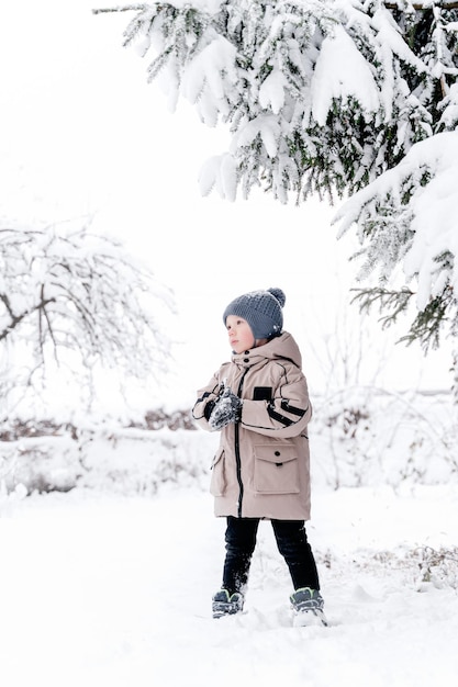 мальчик под деревом в снегу