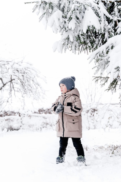 雪の中の木の下の少年