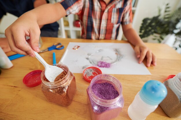 Boy using glitter in artwork