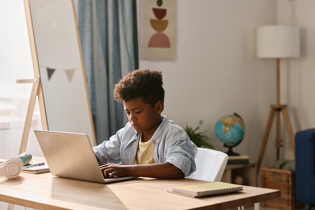 Boy using laptop to do his homework