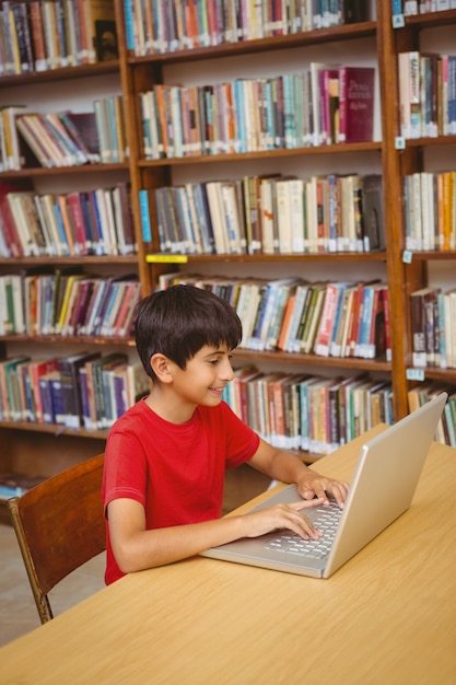 Boy using laptop in the library