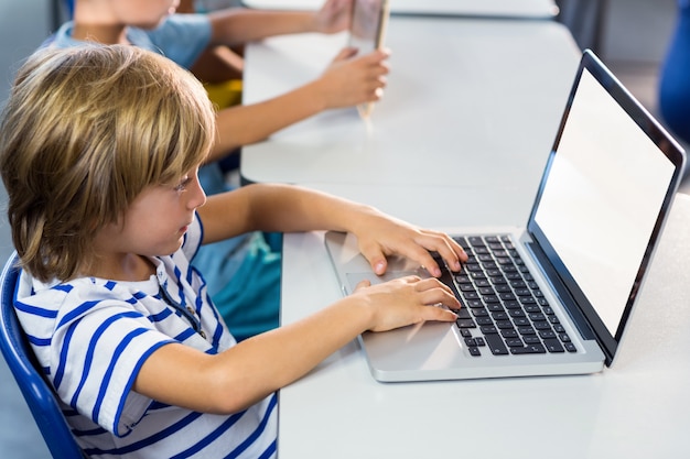 Foto ragazzo che per mezzo del computer portatile