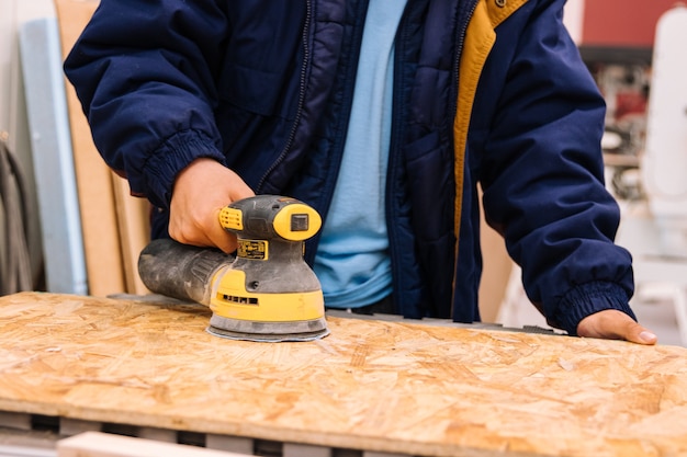 Boy using a sander