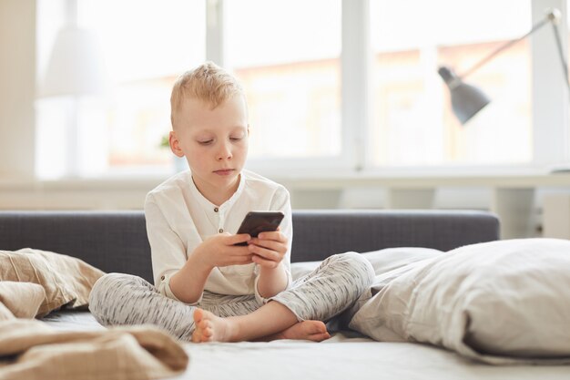 Boy using smartphone in morning