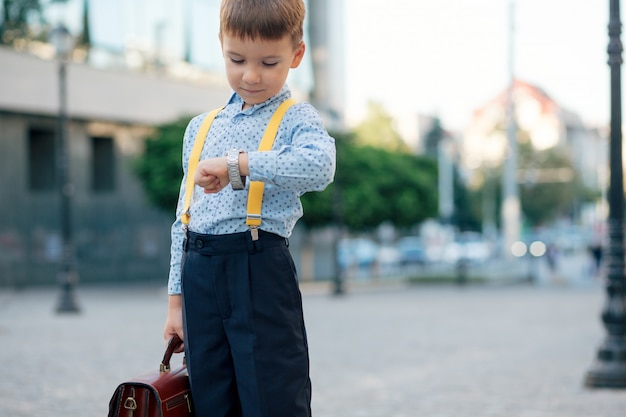 Boy verifying time on his silver watch on his hand