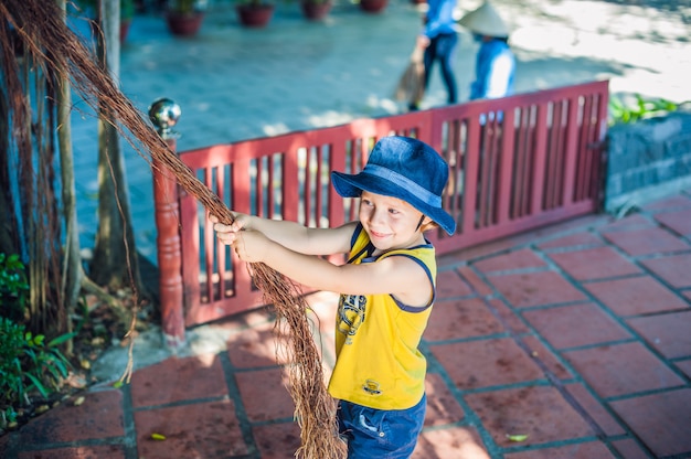 Мальчик на Вьетнаме путешественник на заднем плане Красивое дерево с воздушными корнями