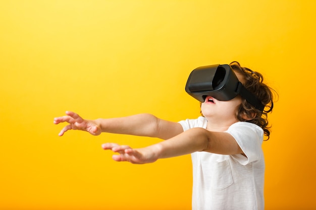 Boy in virtual reality headset with arms extended forward