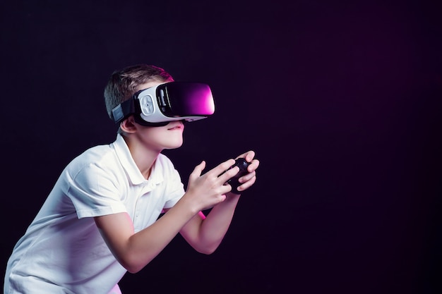 Boy in VR goggles playing with gamepad