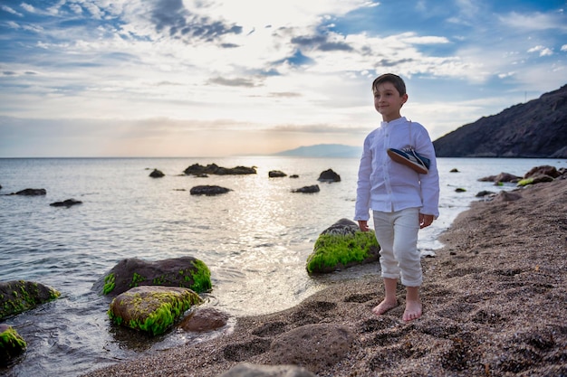 Фото Мальчик гуляет по пляжу в красивой одежде