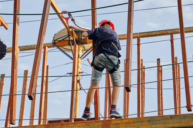 Boy walking on the ropes in a rope park