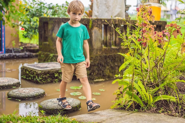 池のタイルの上を歩く少年